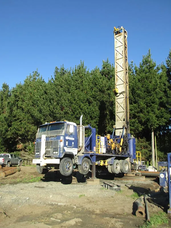 WellDrillers drilling rig with mast raised over a bore