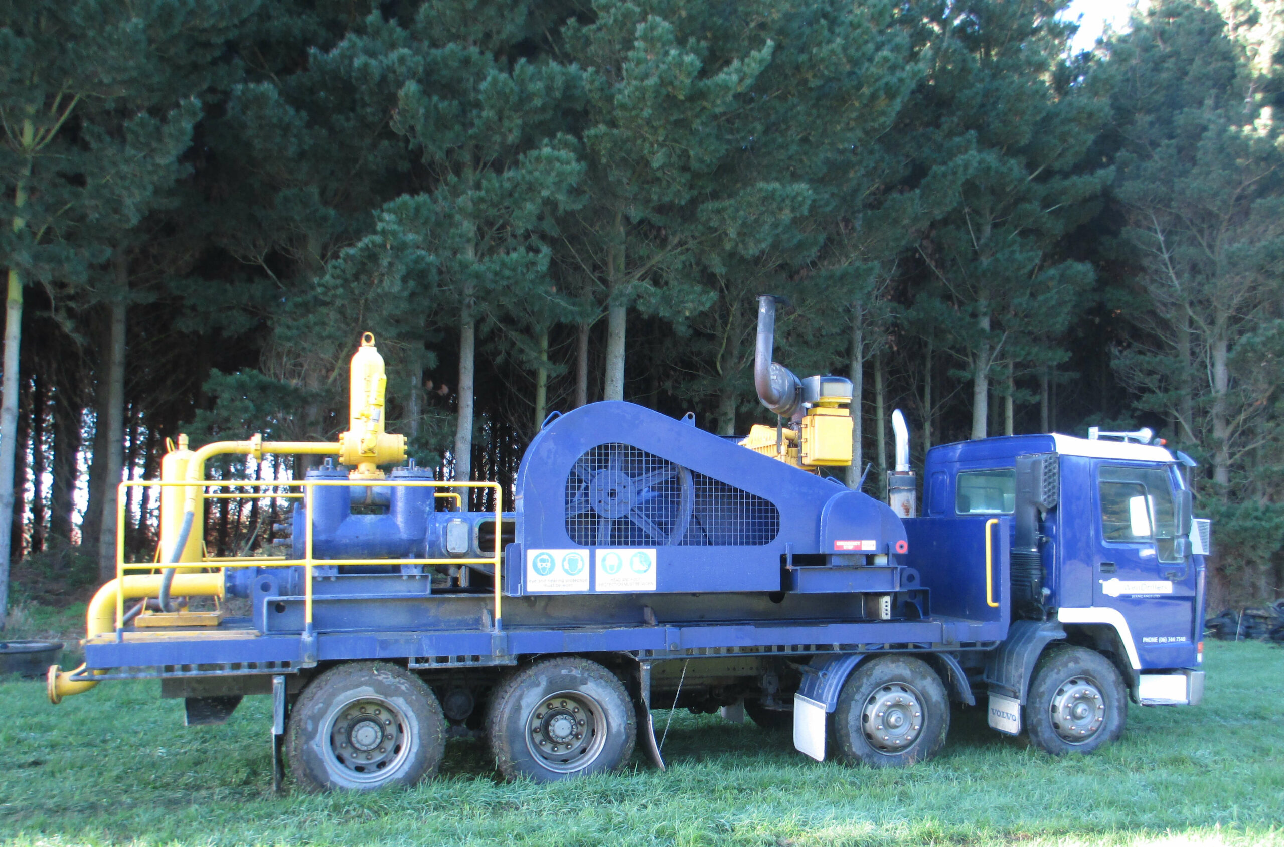 truck 2 WellDrillers drilling rig and support truck on site